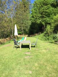 Großer Garten mit Gartenmöbeln und Sonnenschirm